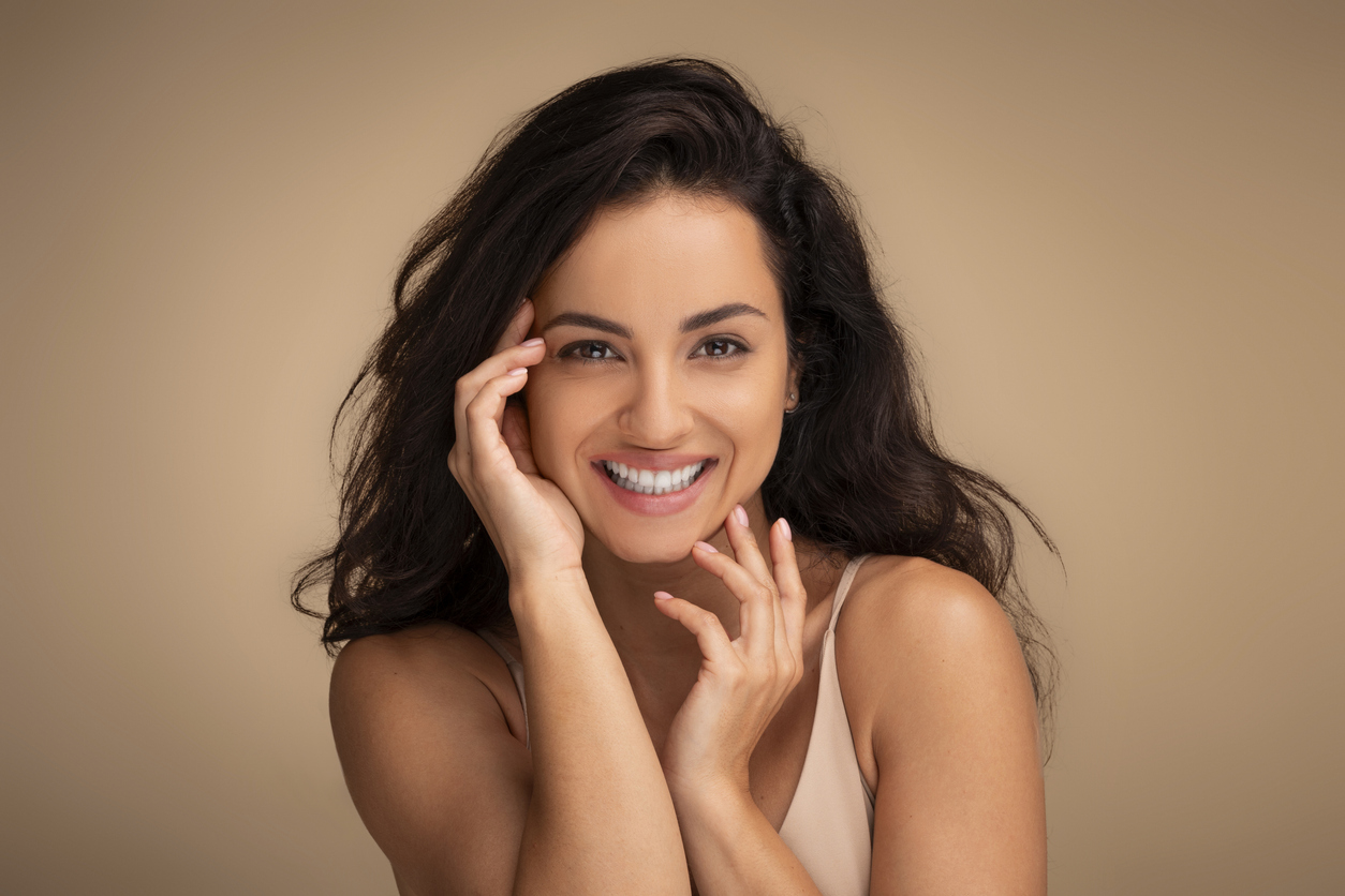 Attraktive dunkelhaarige Frau mit einem fr&ouml;hlichen L&auml;cheln und positiver Ausstrahlung.