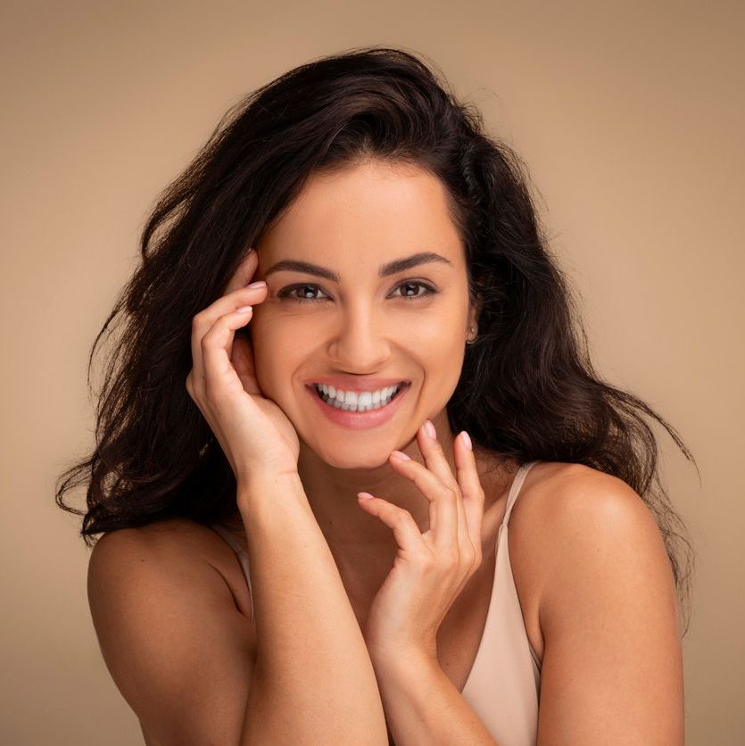 Attraktive dunkelhaarige Frau mit einem fr&ouml;hlichen L&auml;cheln und positiver Ausstrahlung.