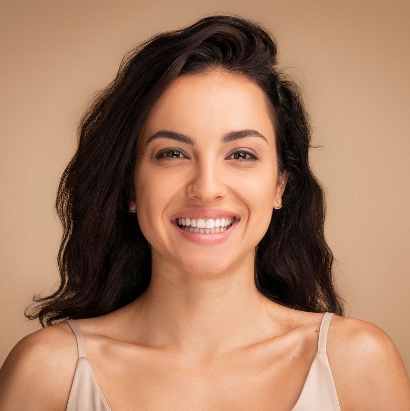 Attraktive dunkelhaarige Frau mit einem fr&ouml;hlichen L&auml;cheln und positiver Ausstrahlung.