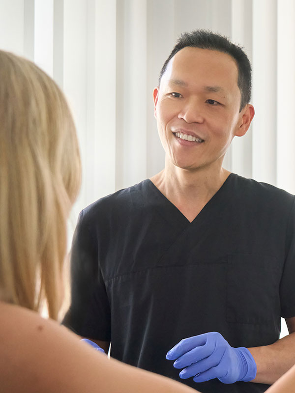 Eine blonde Patientin wird vom Arzt &uuml;ber den Verlauf der Behandlung informiert.