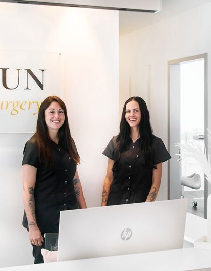 Zwei Frauen stehen lächelnd im Empfangsbereich