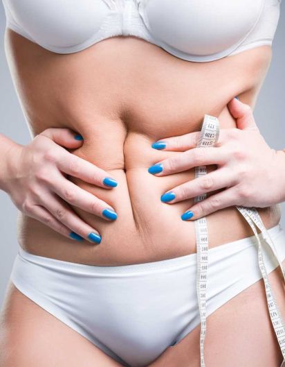 Frau presst mit beiden Händen den Bauch zusammen.